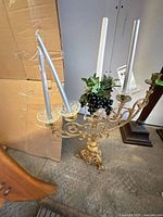 Top view of brass-finish candelabra with candles and faux grapes