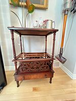 Full view of mahogany side table showing top surface, magazine rack, drawer and legs