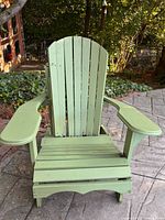Front view of sage green wooden Adirondack chair showing slatted back and seat