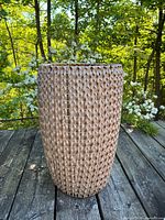 full view of tall woven planter basket outdoors