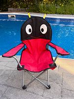 front view of children’s ladybug folding chair by pool