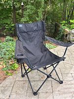 Front view of black Mac Sports folding camp chair on patio