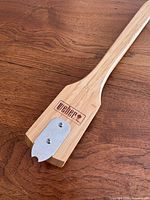 Full view of Weber bamboo grill cleaning tool showing logo and metal scraper
