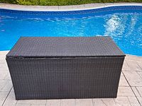 Closed storage box beside pool showing exterior wicker condition