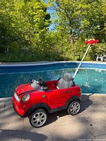 Full side view of Mini Cooper push car beside pool