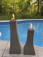 Both wicker burner towers lit beside pool