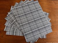 All eight placemats fanned out on wood table