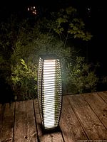 Lantern illuminated at night showing wicker pattern and white inner glow
