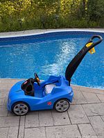 Side view of blue Step2 push car beside pool