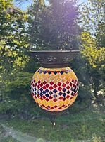 Lantern hanging outdoors showing full globe, chain, and canopy