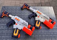 Two identical Nerf Super Soaker Tornado Strike water blasters on table