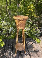 Full view of wicker bamboo plant stand outdoors