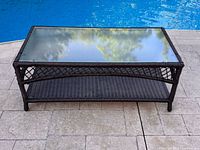 Full view of rectangular wicker coffee table by a pool