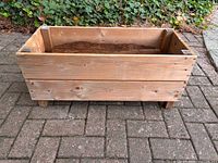 front angled view of wooden planter showing overall form and feet
