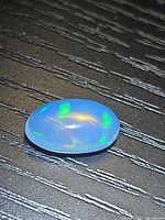 Top view of oval crystal jelly opal showing play-of-color