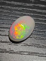 Top view of oval opal showing intense multicolour fire