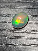 Top view of oval opal showing vivid color flashes