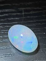 Top view of oval crystal opal showing multicolour play-of-colour