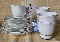 Stacked dessert plates and saucers with two teacups showing butterfly handles