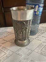 Front view of pewter goblet beside bottle for scale