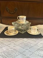 Three patterned demitasse cups on saucers displayed on tray