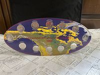 Front view of oval display showing 12 mounted quarters and map graphic