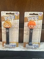 Front view of both sealed Hermione and Ron Pez dispensers on backing cards