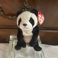 Front view of Ty China panda plush seated on glass stand