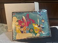 Front view of sealed coin map with coins visible, box and stand