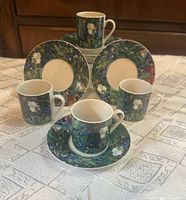 Complete set of four espresso cups each on its saucer showing artwork