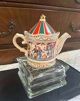 Full view left side of circus tent teapot on glass riser