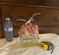 Front view showing entire sculpture with water bottle and tape for scale