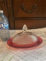 Complete Indiana Glass Diamond Point ruby flash butter dish beside water bottle for scale