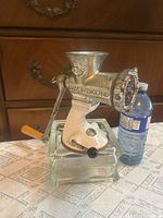 Left side view of Spong No. 801 meat grinder mounted on base with handle visible
