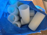 Top view into blue tote showing multiple white battery-operated pillar candles