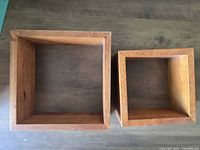 Top-down view of two square wooden floating shelves showing size difference and condition