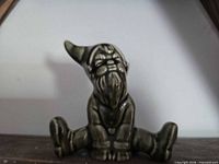 Front view of seated ceramic leprechaun figurine