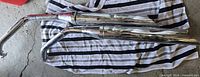 Both chrome exhaust pipes side by side on striped towel