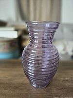 Front view of translucent purple ribbed glass vase