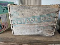 Side view showing Canada Dry logo and wire-bound wooden construction