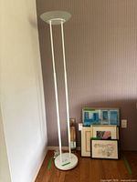 Full view of lamp next to stacked framed prints