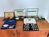 Overview of all cased flatware sets on cabinet