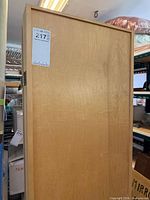 Full view of one panel showing light brown wood veneer finish