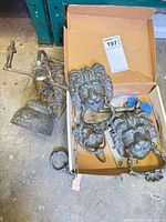 Box containing two lion head knockers, bell assembly, hinges and hardware
