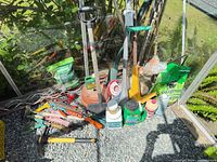 Overview of assorted garden tools, fertilizer bags, pots, chemicals, stakes