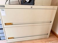 Front view of beige 2-drawer lateral file cabinet showing lock and recessed handles