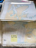 Stack of CHS nautical charts in plastic sleeves, label indicates West Coast Van Isle