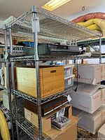 Full view of chrome wire shelving loaded with boxes and electronics