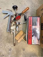 Group shot of angle grinder box with assorted hand tools laid out