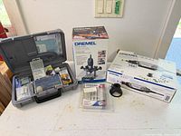 Overall lot showing Dremel 3000 and 335 boxes, rotary tool in carrying case, accessory packs and router base